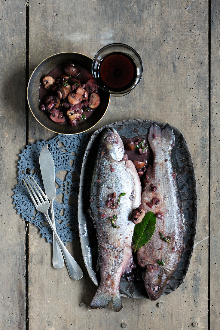 Two trout fish in red wine on plate
