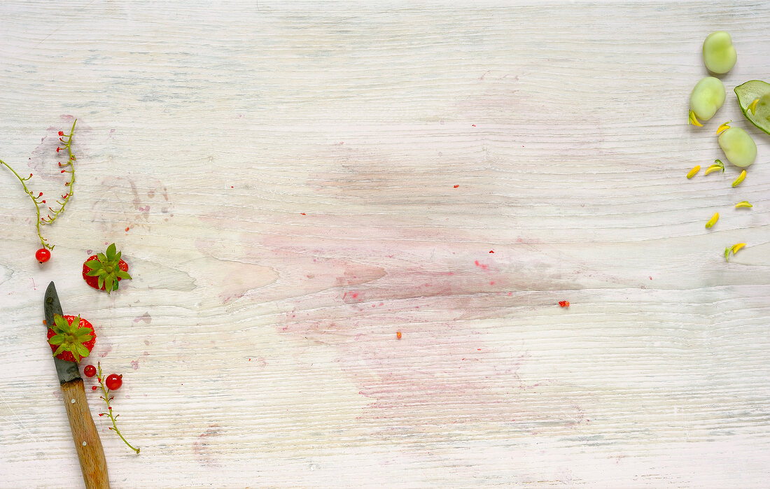 Strawberries with knife on wooden table, overhead view