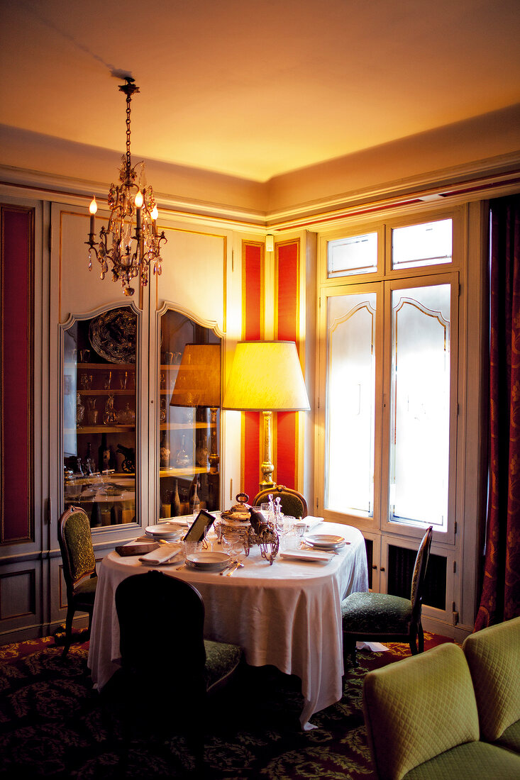 Interior of restaurant with dining table and illuminated lamp