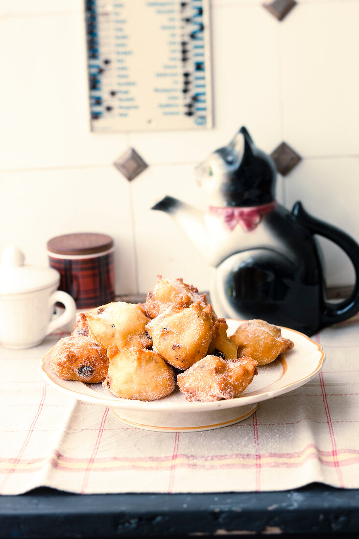Pufferkes on plate with cat shaped tea kettle on table