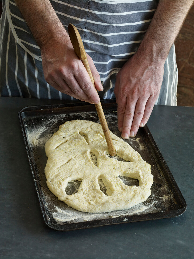 Close-up of making shapes on dough for preparation of fougasse, step 3