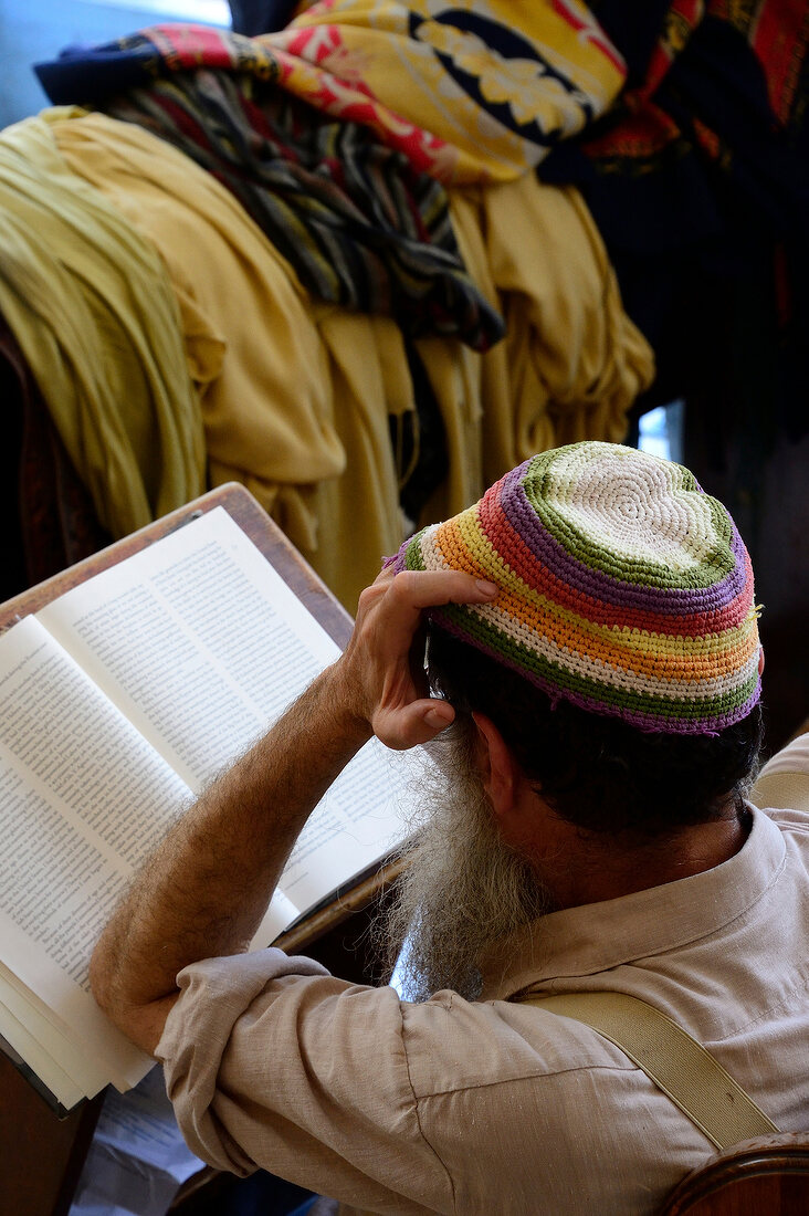 Rear view of man reading Torah with hands on head, Ari Ashkenazi Synagogue, Safed, Israel