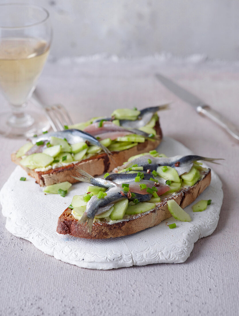 Toasted bread with marinated anchovies on board
