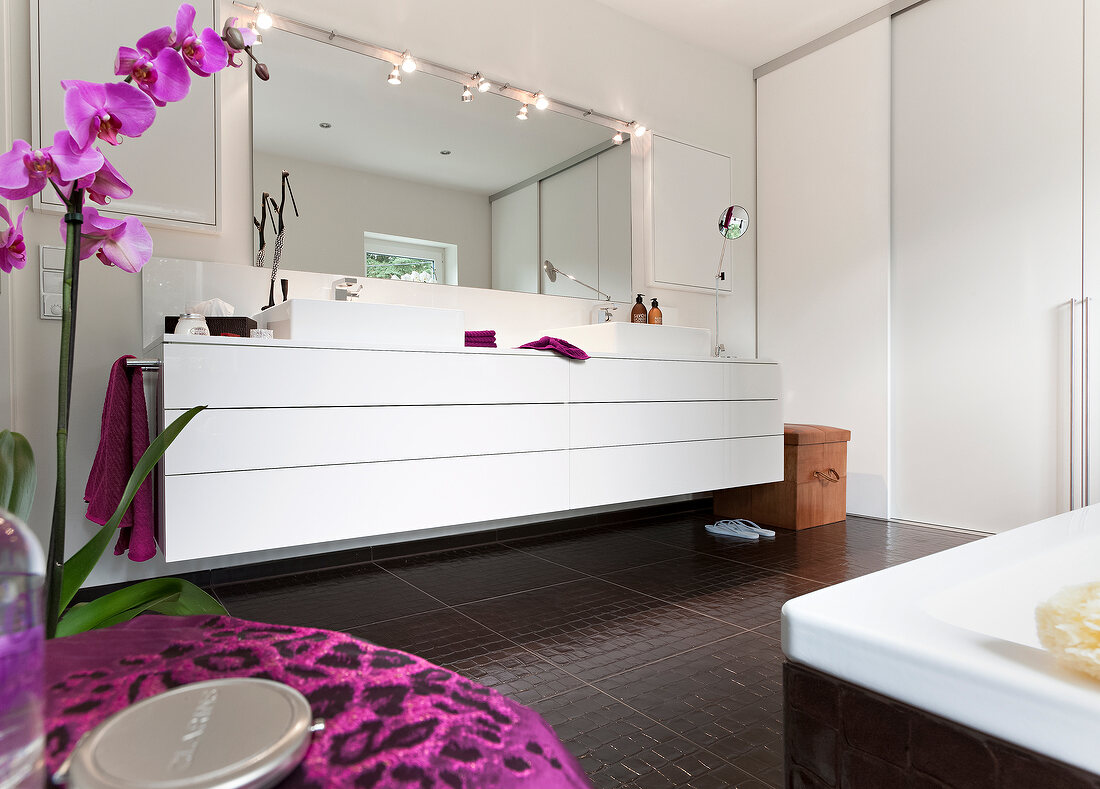 Vanity in bathroom with sink, mirror and illuminated lights