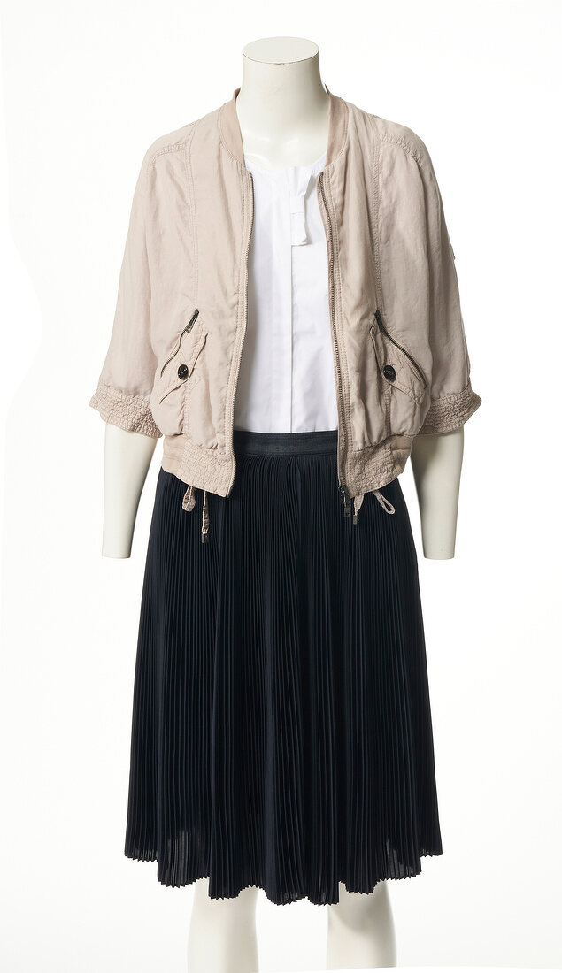 Beige jacket, white shirt and black pleated skirt on mannequin