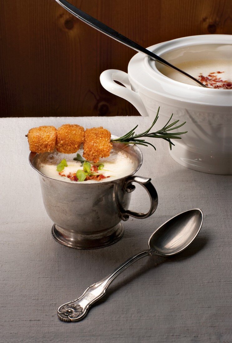Potato soup with baked mountain cheese cubes in cup
