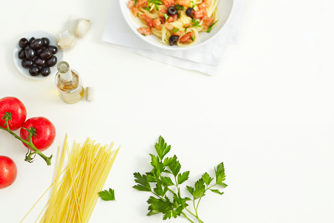 Various ingredients for pasta dish on white background