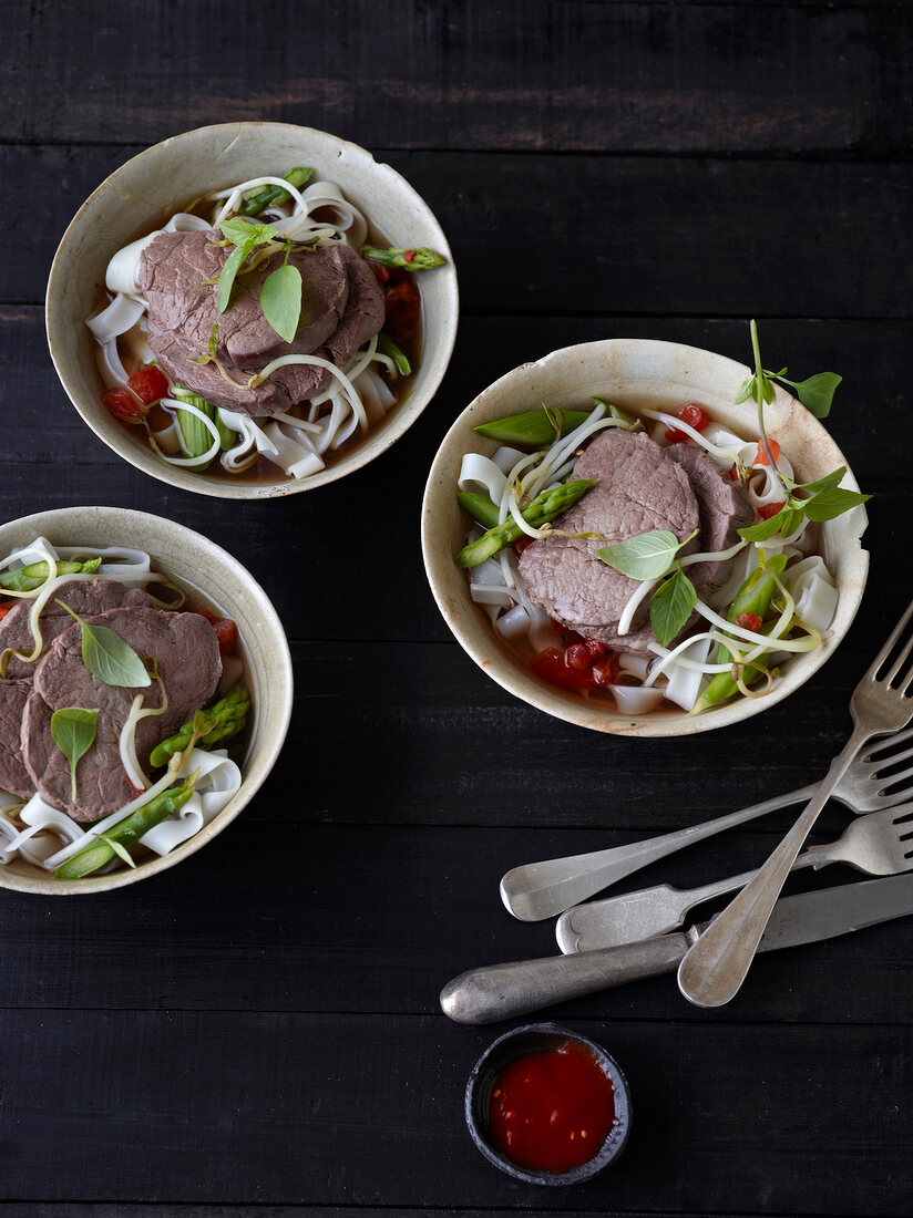 Poached fillet of beef with rice noodles in three bowls
