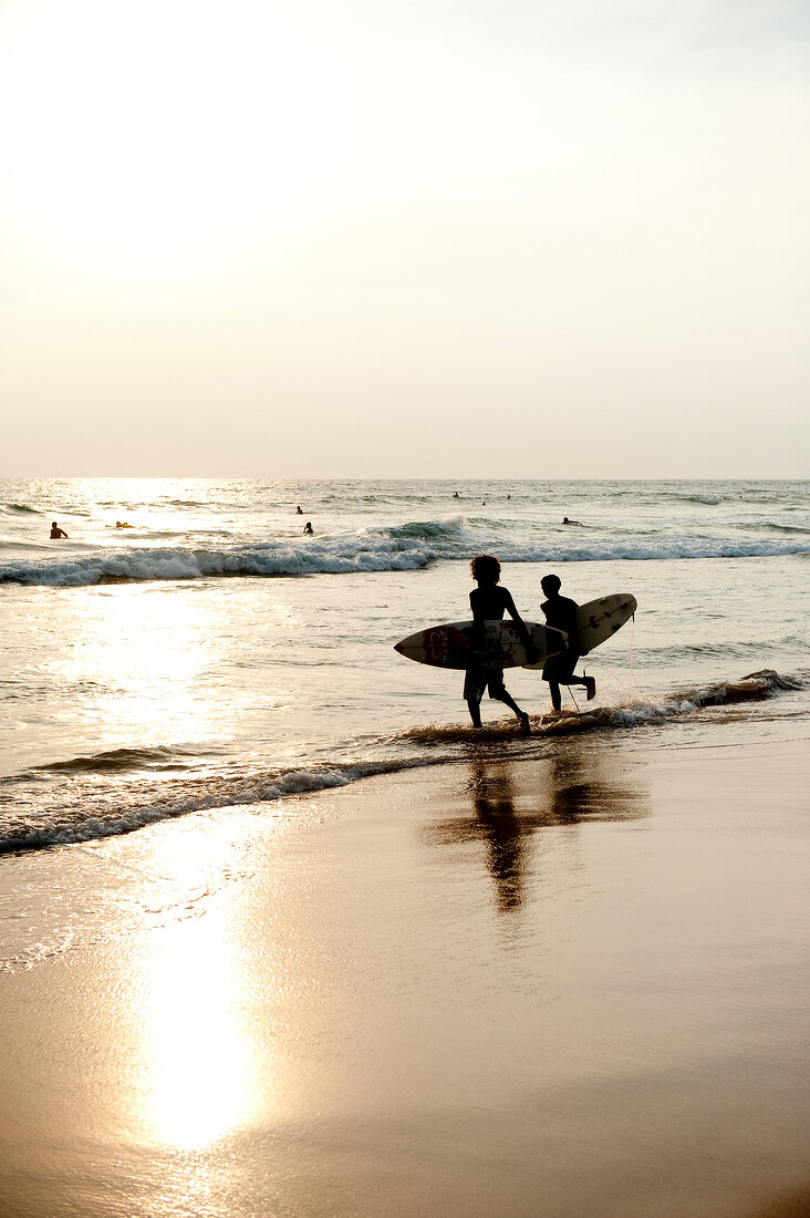 Kids running with surf board on beach, Indian Ocean, Hikkaduwa, Sri Lanka