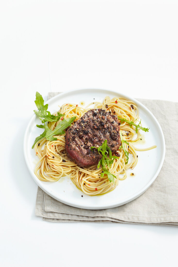 Steaks with noodles, espresso and pepper on plate