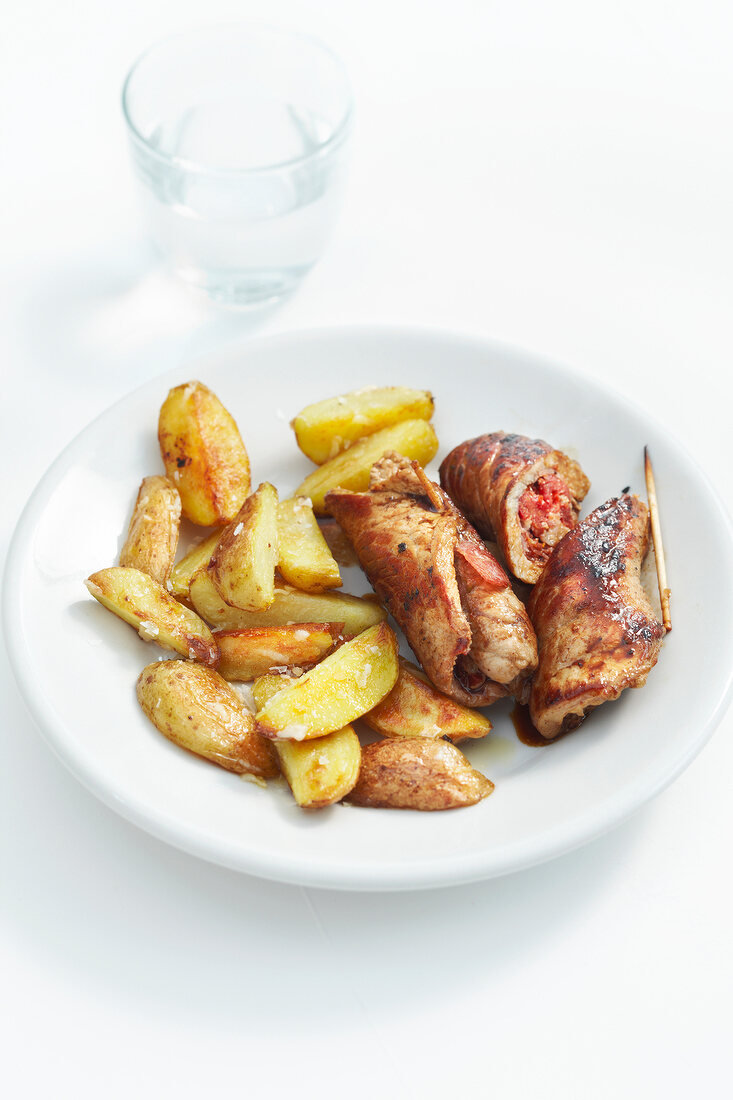 Involitini with tomato filling and fried potatoes on plate