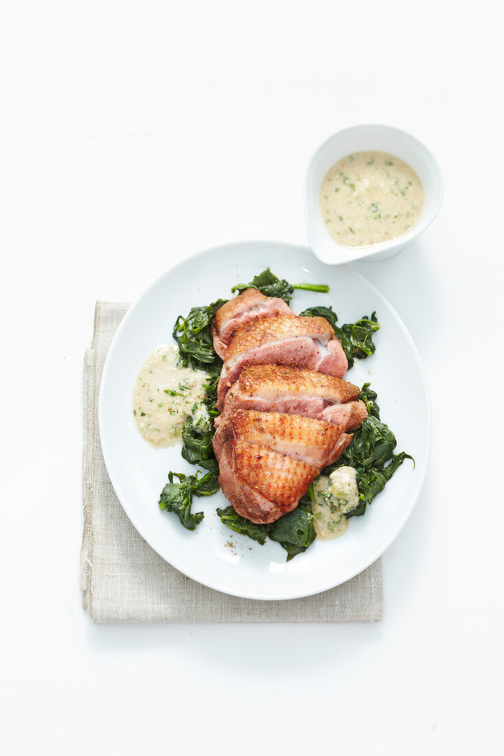 Duck breast with spinach and almond chutney on plate