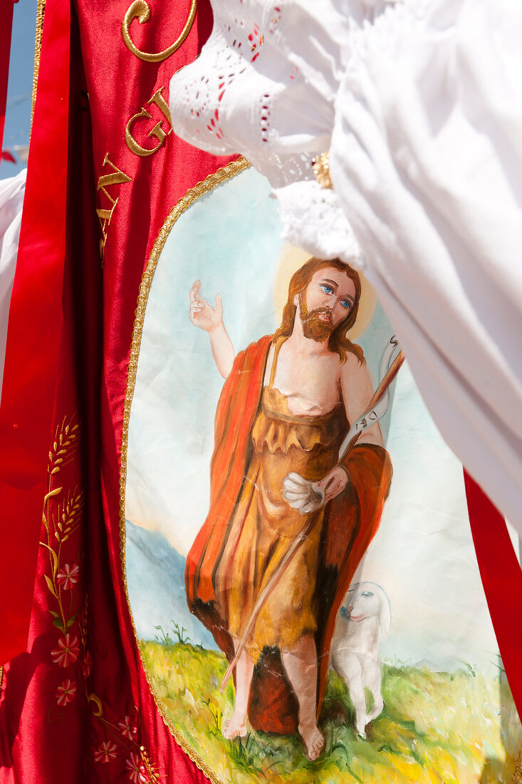 Jesus on red flag during Sant'Efisio procession, Pula, Sardinia, Italy