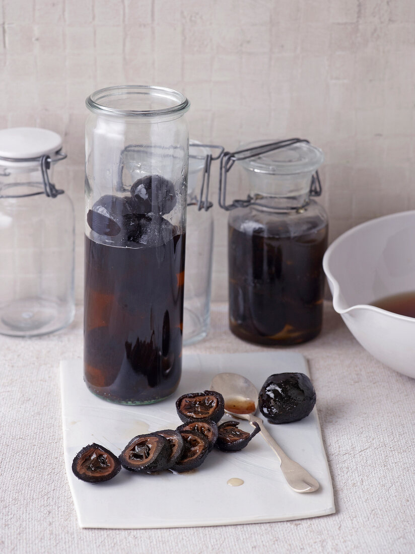 Spiced black nuts in jars and slices of black nuts on board