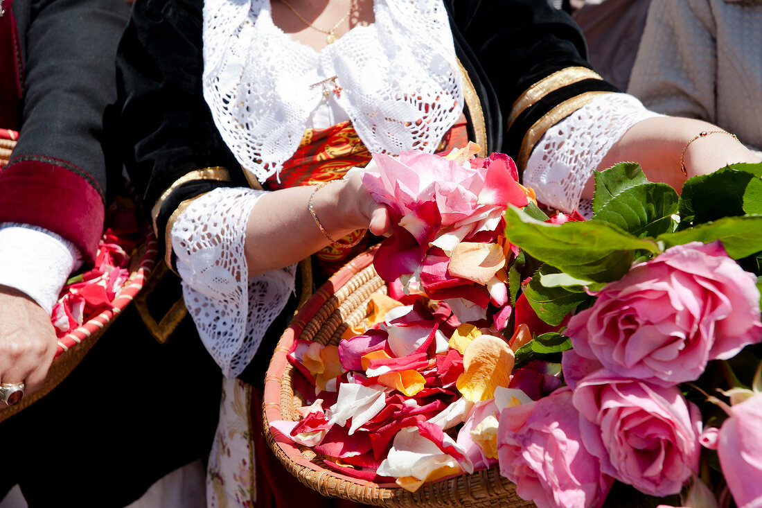 Close-up of woman holding basket of roses, Sardinia, Italy
