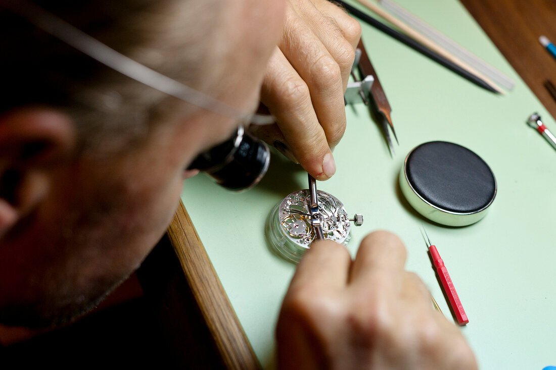 Close-up of man repairing watch on table