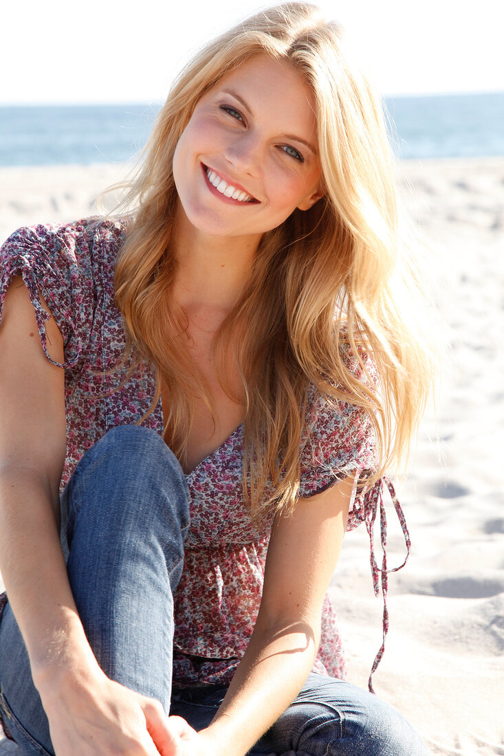 Portrait of beautiful blonde woman wearing floral pattern blouse, smiling