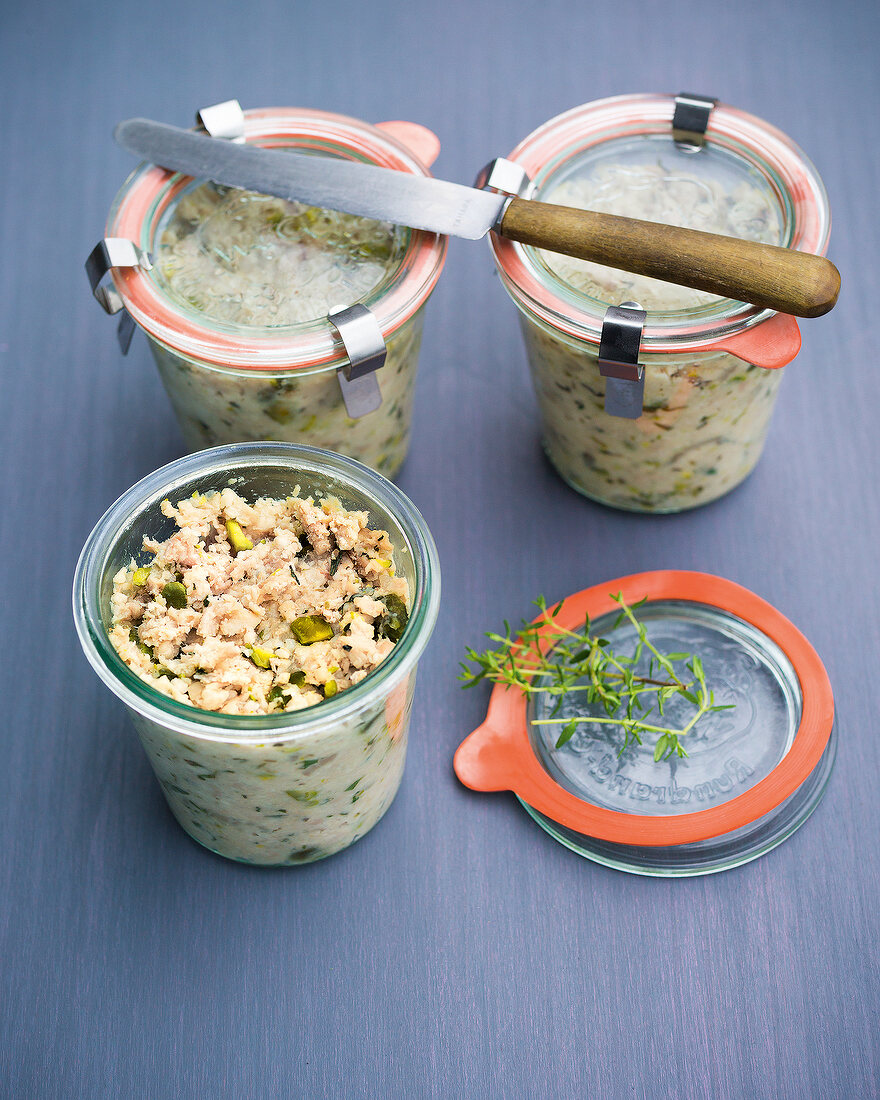 Sausage with herbs and pistachios in glass containers