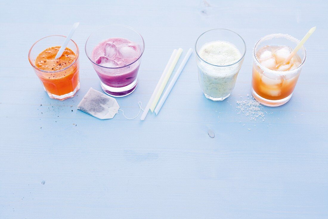 Vier erfrischende Mixgetränke in Gläsern