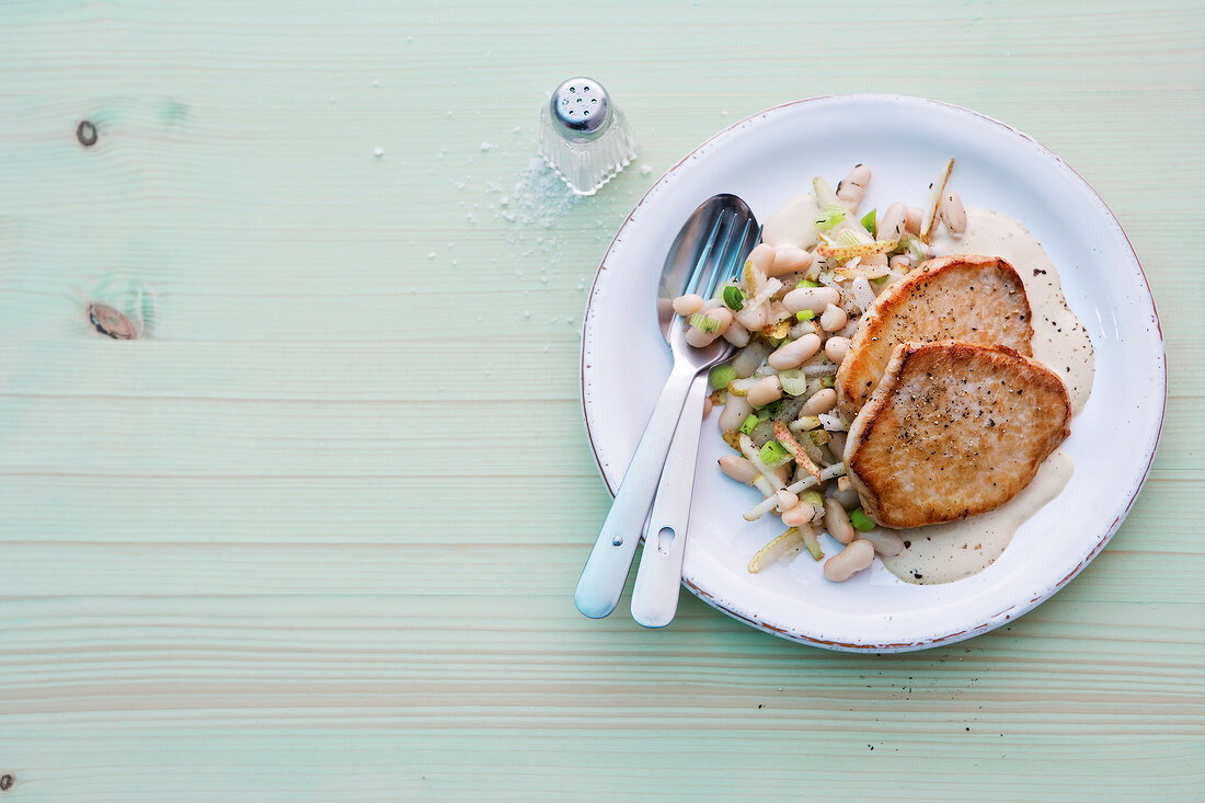 Cutlet with white beans and pear on plate