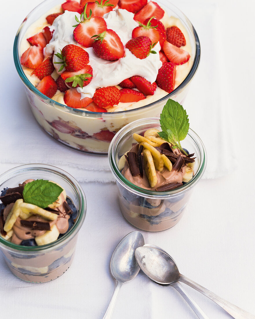 Erdbeer trifle and chocolate curd with berries and banana in bowls
