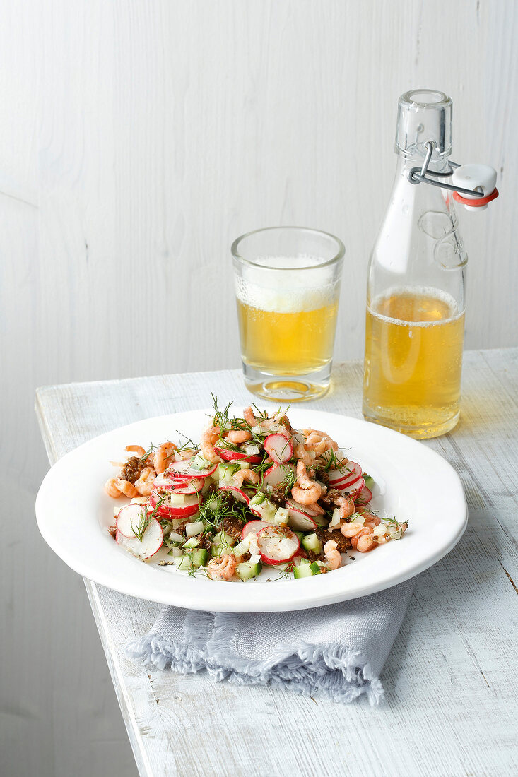 Plate of pumpernickel salad with beer on table