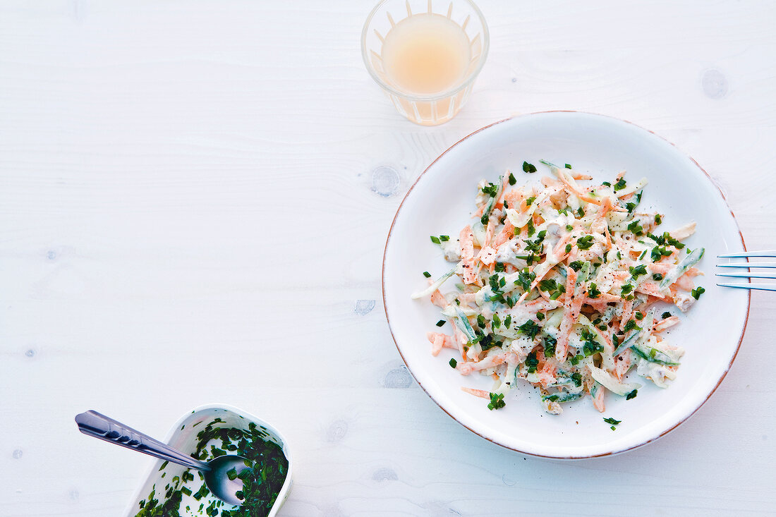 Bowl of carrot and cucumber salad with walnut cream, overhead view