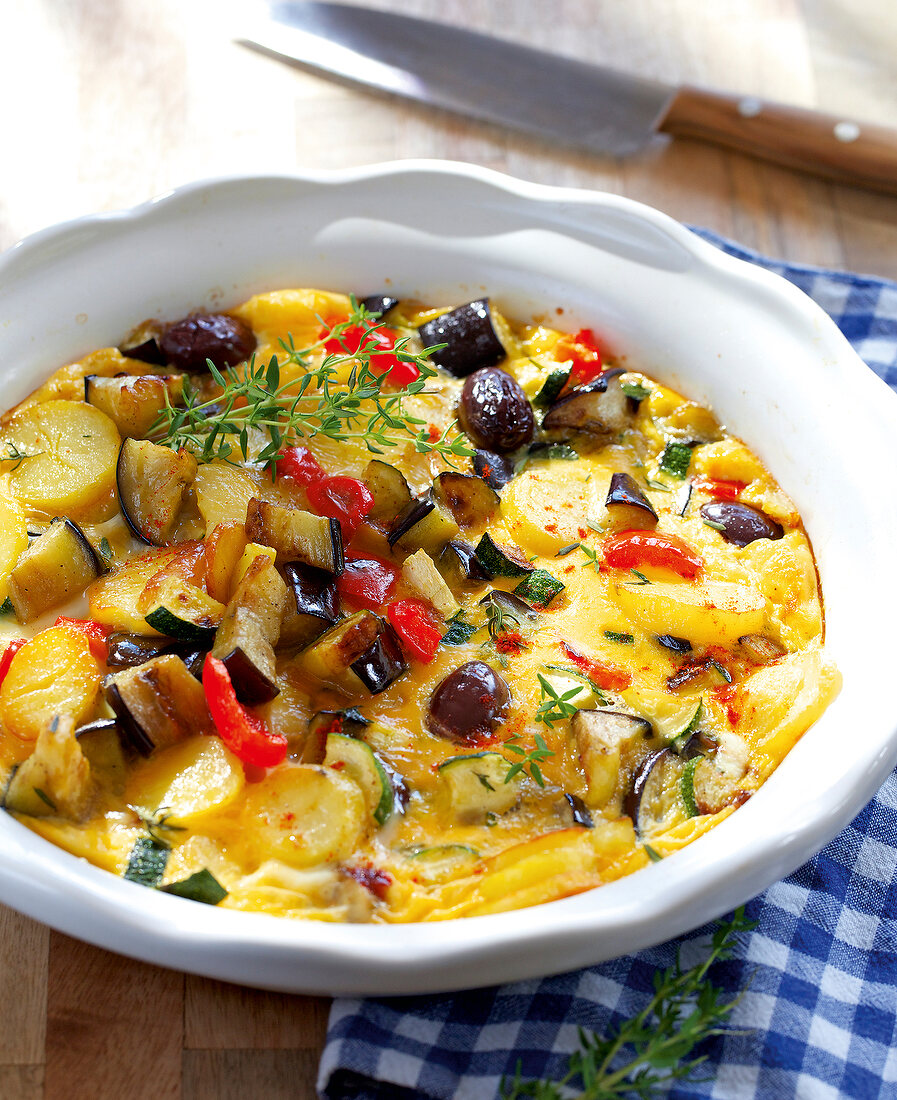 Bowl of Spanish potato tortilla on checked tablecloth