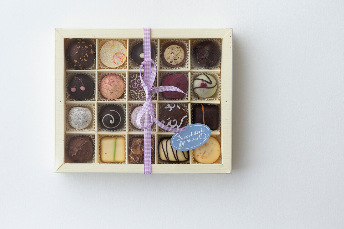 Box of different praline mixed chocolates on white background