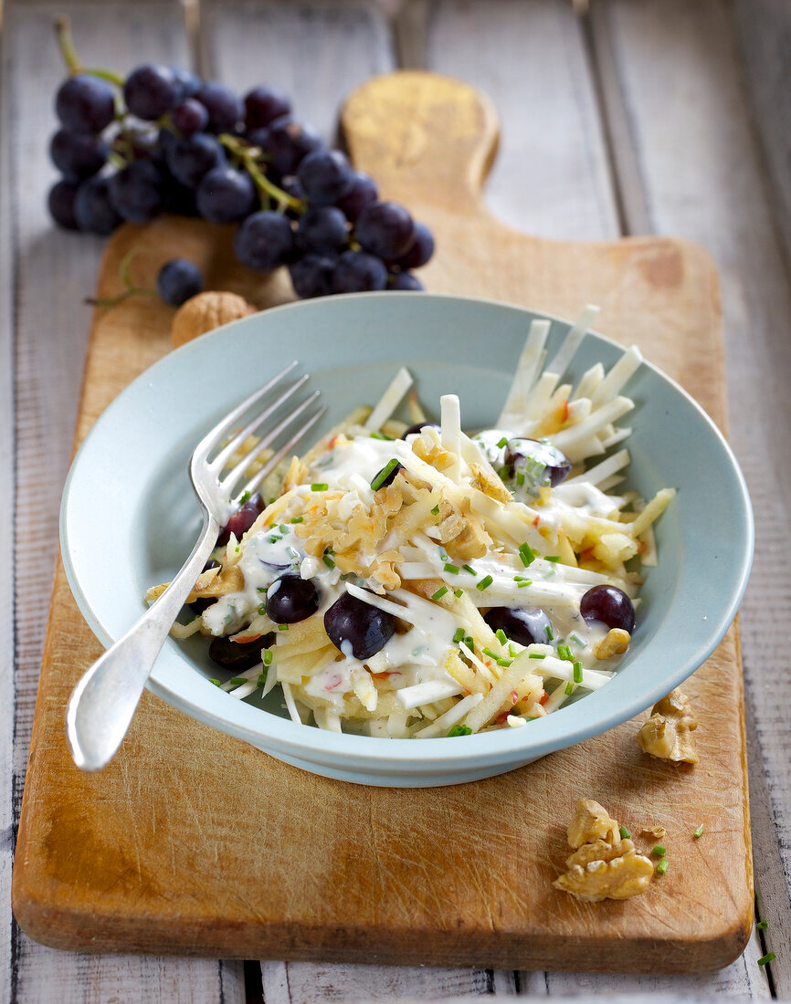 Celery salad with grapes and walnuts in bowl
