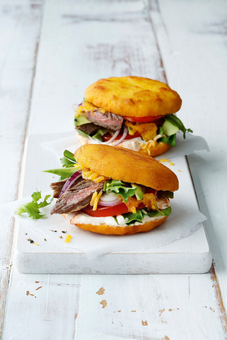 Two stuffed arepas on white board