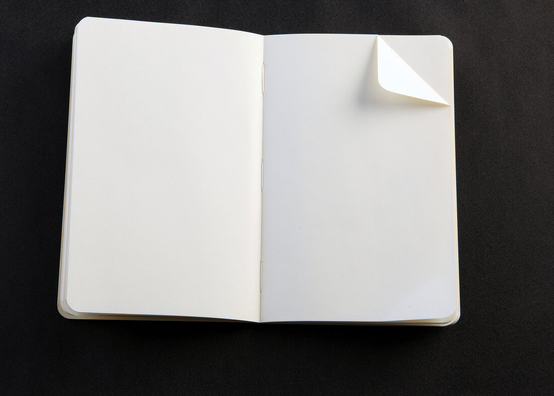 Notizbuch mit Eselsohr, schwarzer Hintergrund