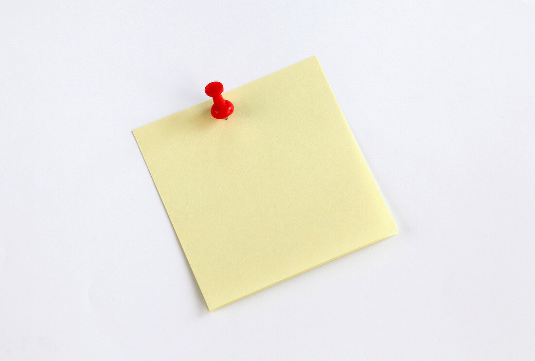 Yellow sticky note with red push pin on white background