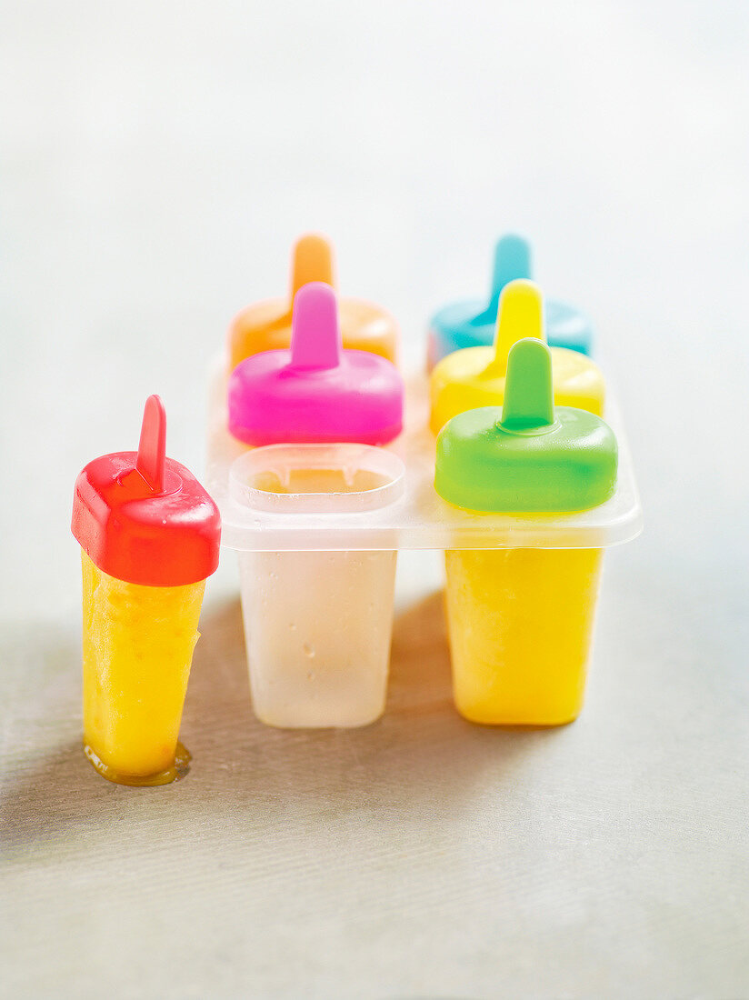 Colourful ice pop molds and fruity orange ice pop