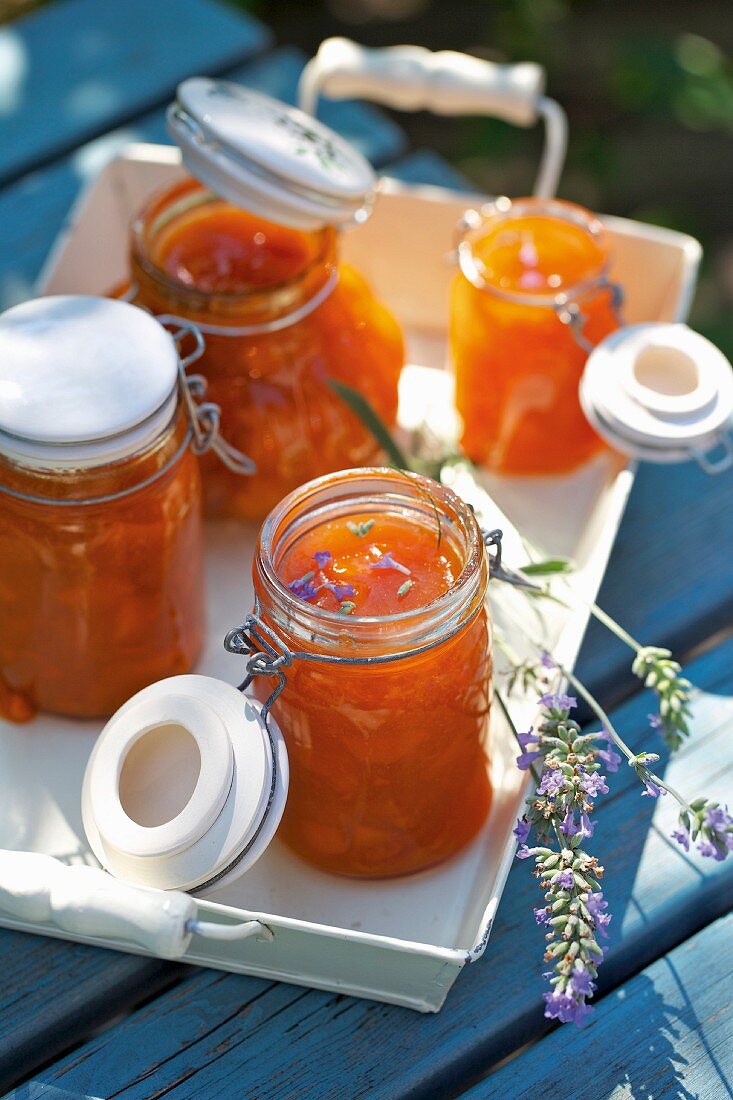 Jars of apricots jam on a tray outside