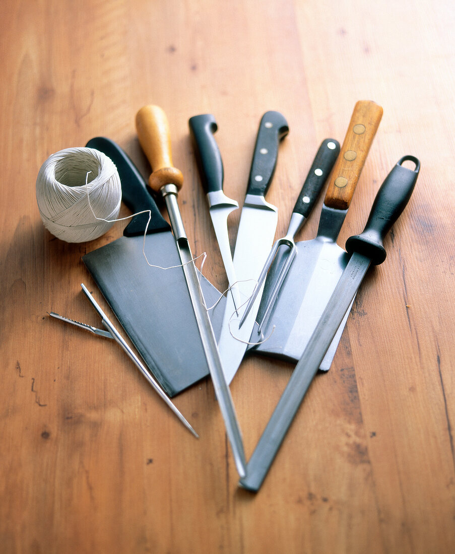 Different tools and knives on wooden surface