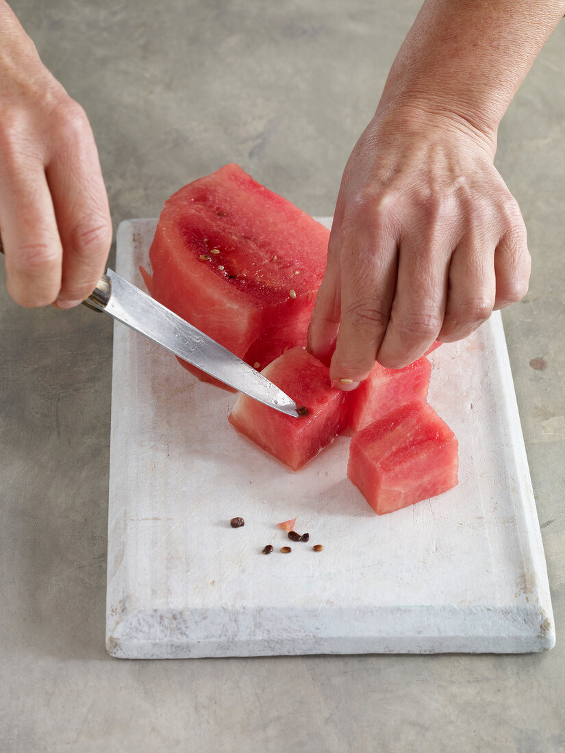 Close-up of cutting pieces of watermelon on chopping board for preparation of jam
