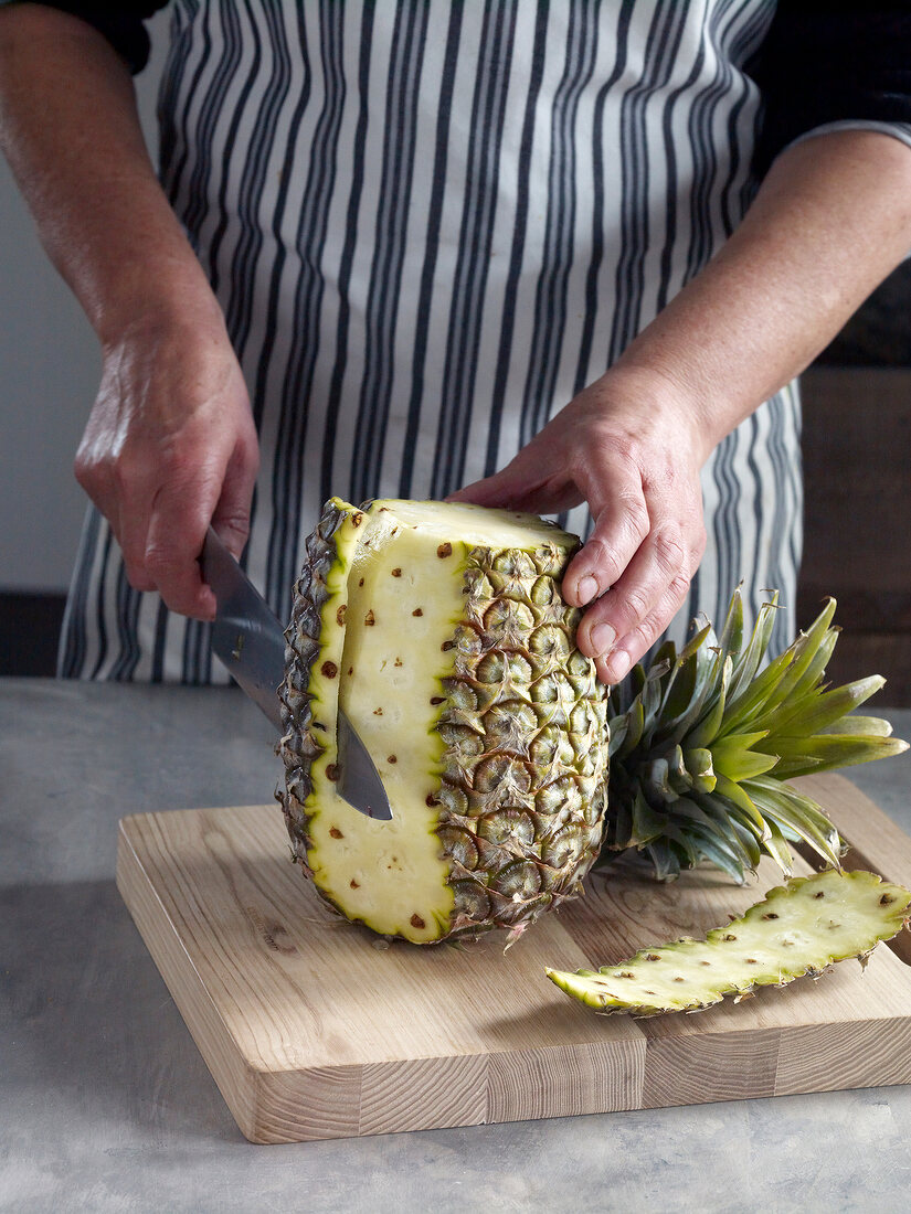 Close-up of peeling pineapple on chopping board for preparation of jam