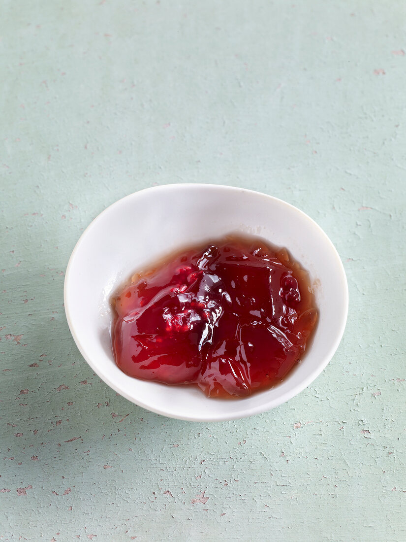 Red current jelly with raspberries in bowl