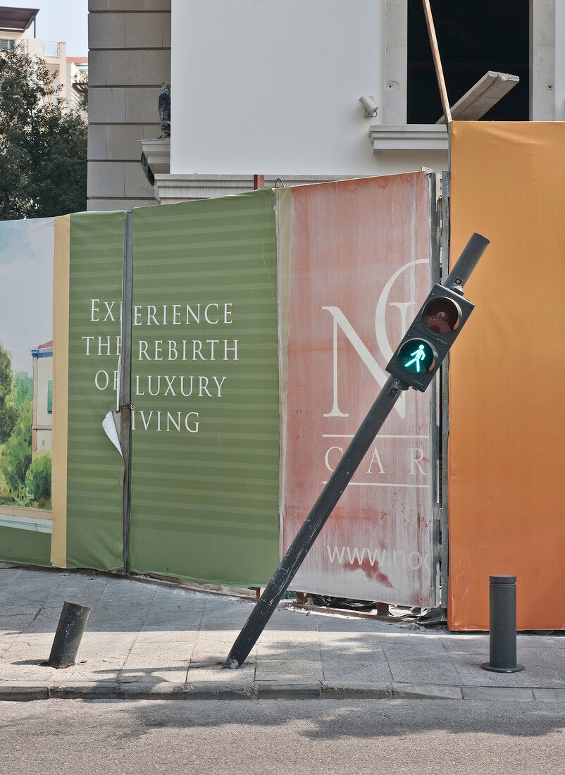 Bent traffic signal in front of construction of luxury apartments in Beirut, Lebanon