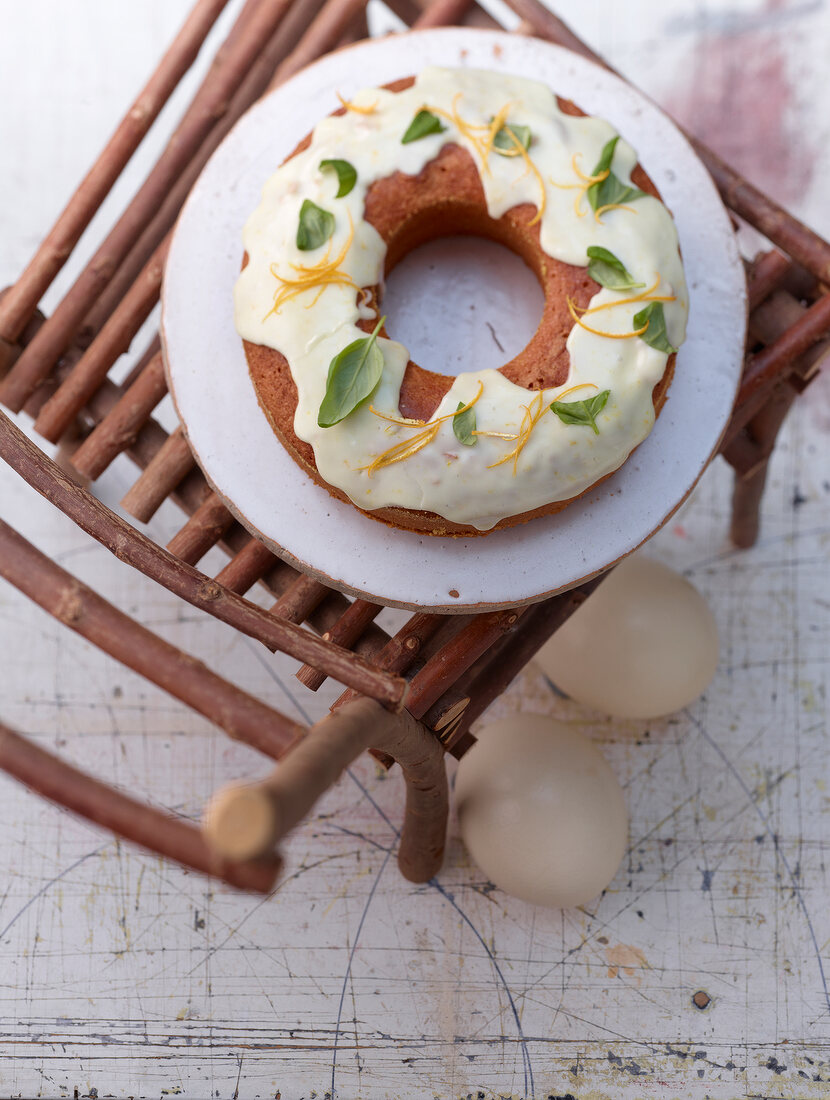 Plate of polenta and orange ring with basil syrup on wooden stool