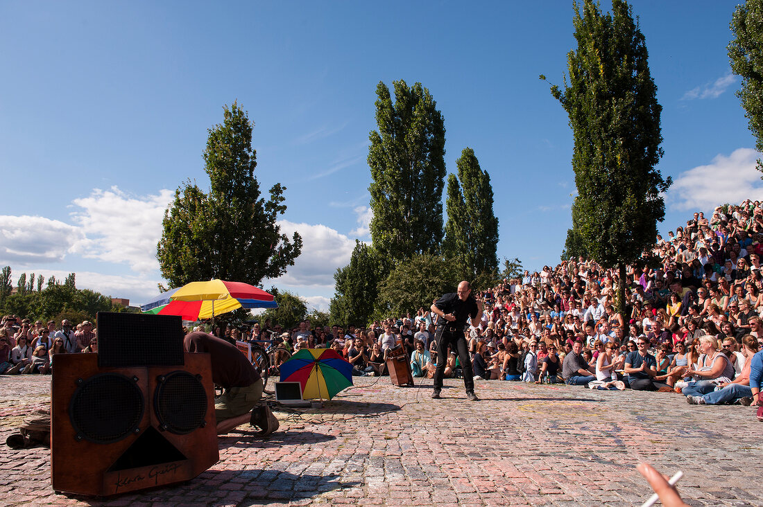 Crowd watching man performing at an event in Prenzlauer Berg, Berlin, Germany