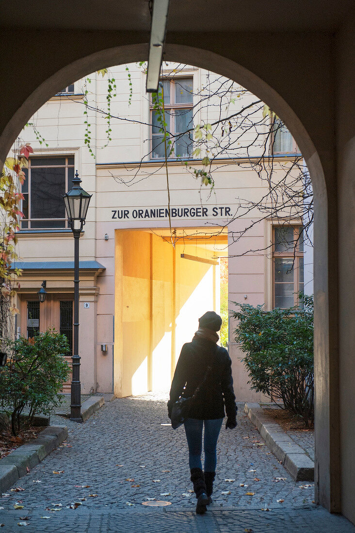 Rear of woman walking on Oranienburger streets, Berlin, Germany