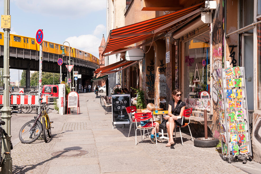 Woman sitting in front of shop in Wrangelkiez, Berlin, Germany