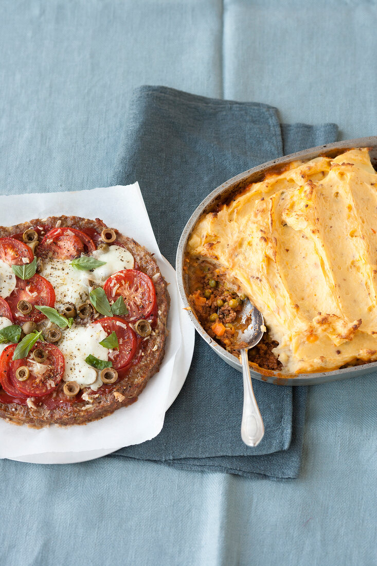 Meat pizza and shepherd's pie on plate and in baking tray
