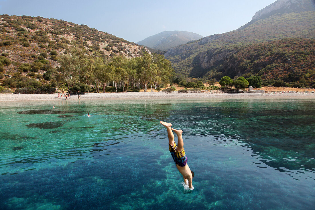 Man diving into Aegean sea near Resadiye peninsula in Turkey