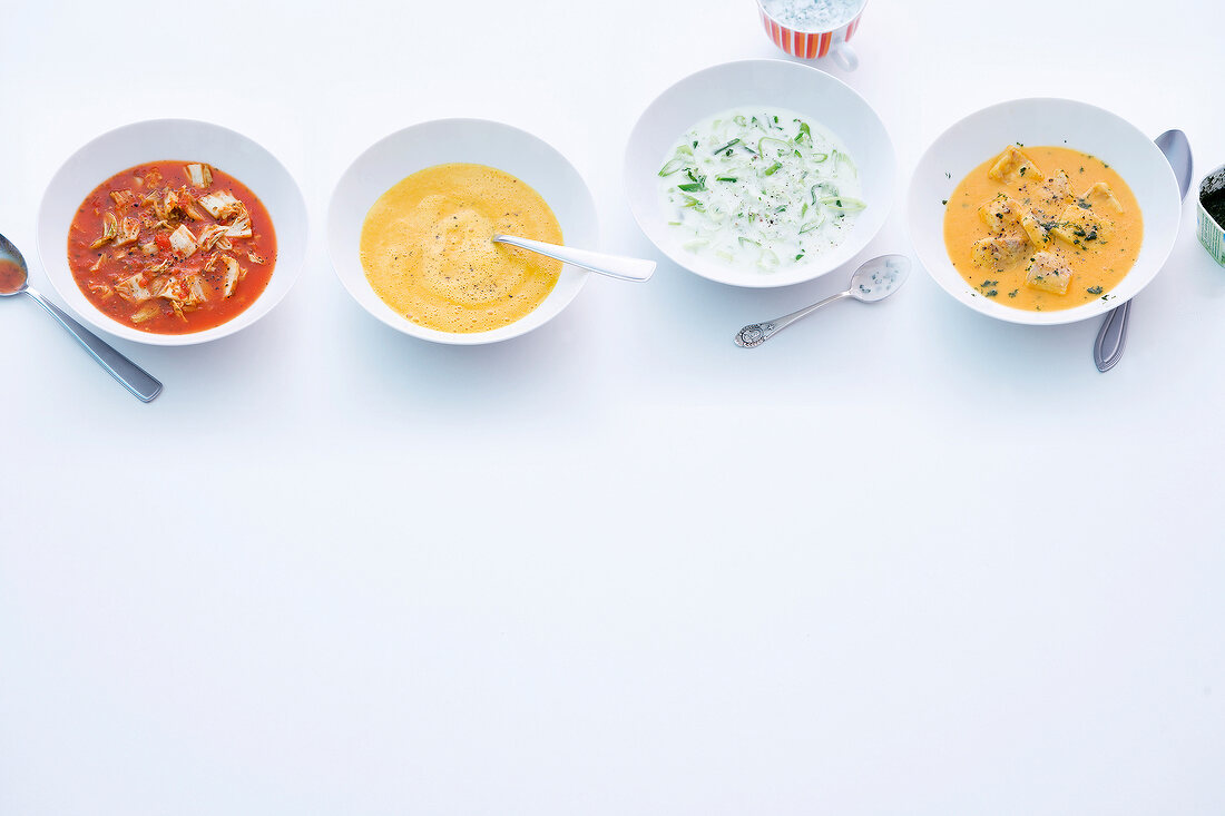 Various soups in bowls on white background