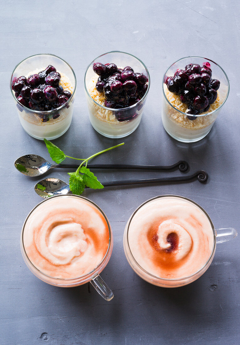 Cassis cream in bowl and blueberry with coconut layer in glass, overhead view