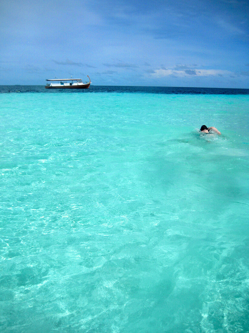 Schnorchlerin im Wasser, Boot, Insel Dhigufinolhu, Malediven