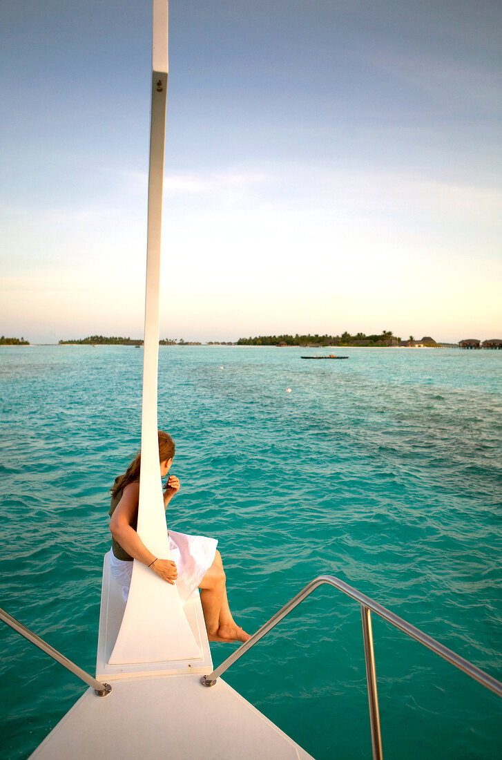 View of woman on boat and island Veliganduhuraa, Maldives